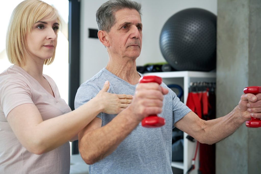Inicio 4 Female physical therapist conducts dumbbell training