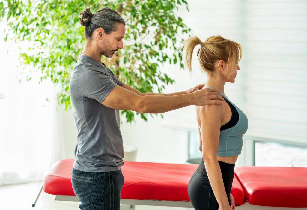 Inicio 5 Male osteopath performing postural evaluation on female patient